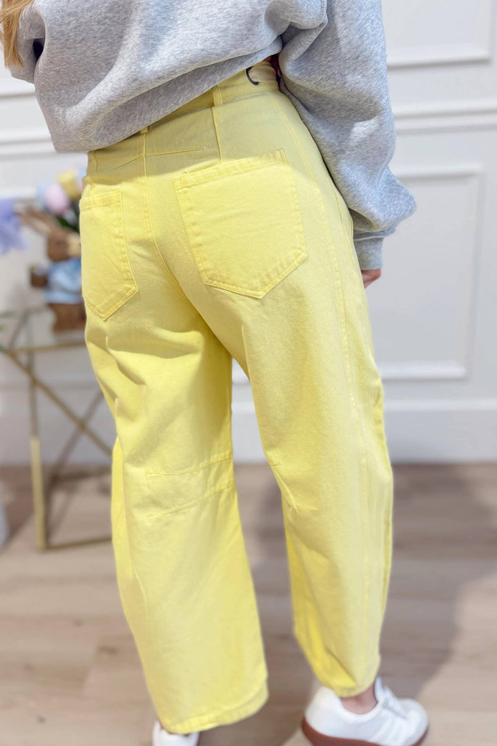 Model wearing yellow washed eyelet barrel pants — Heritage 1823 boutique.