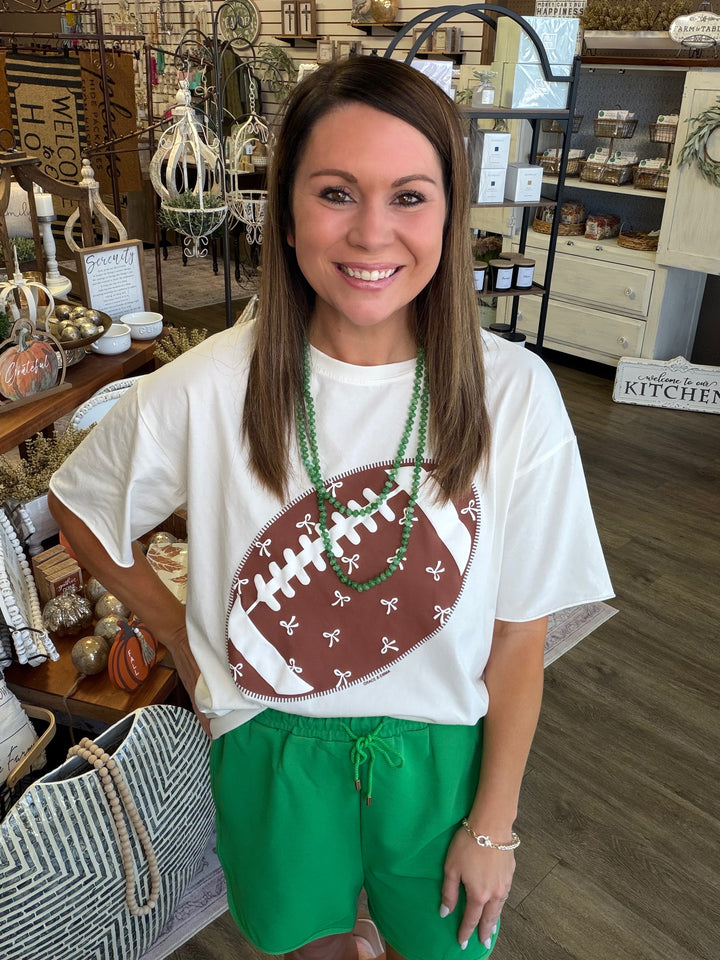 Front view of Football Bow Boxy Graphic Tee — Heritage 1823 boutique in Dublin, TX.