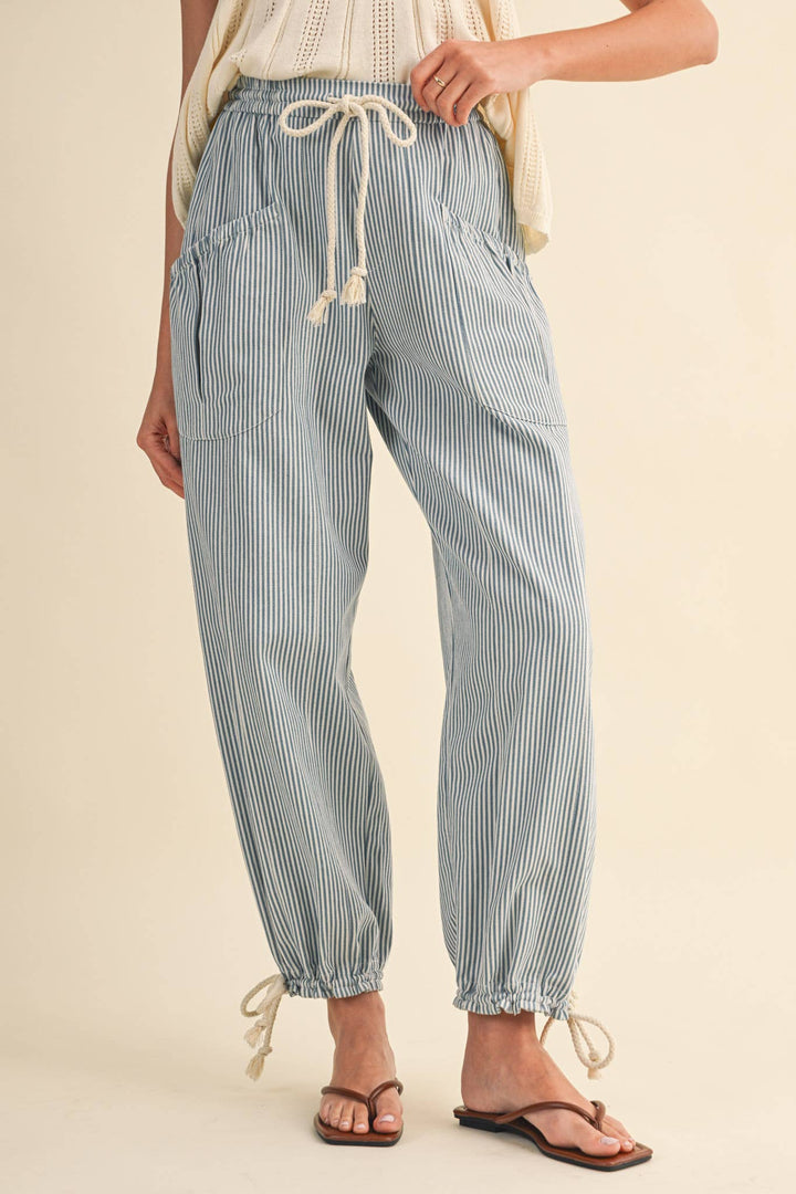 Model wearing denim stripe parachute pants — Heritage 1823 boutique.